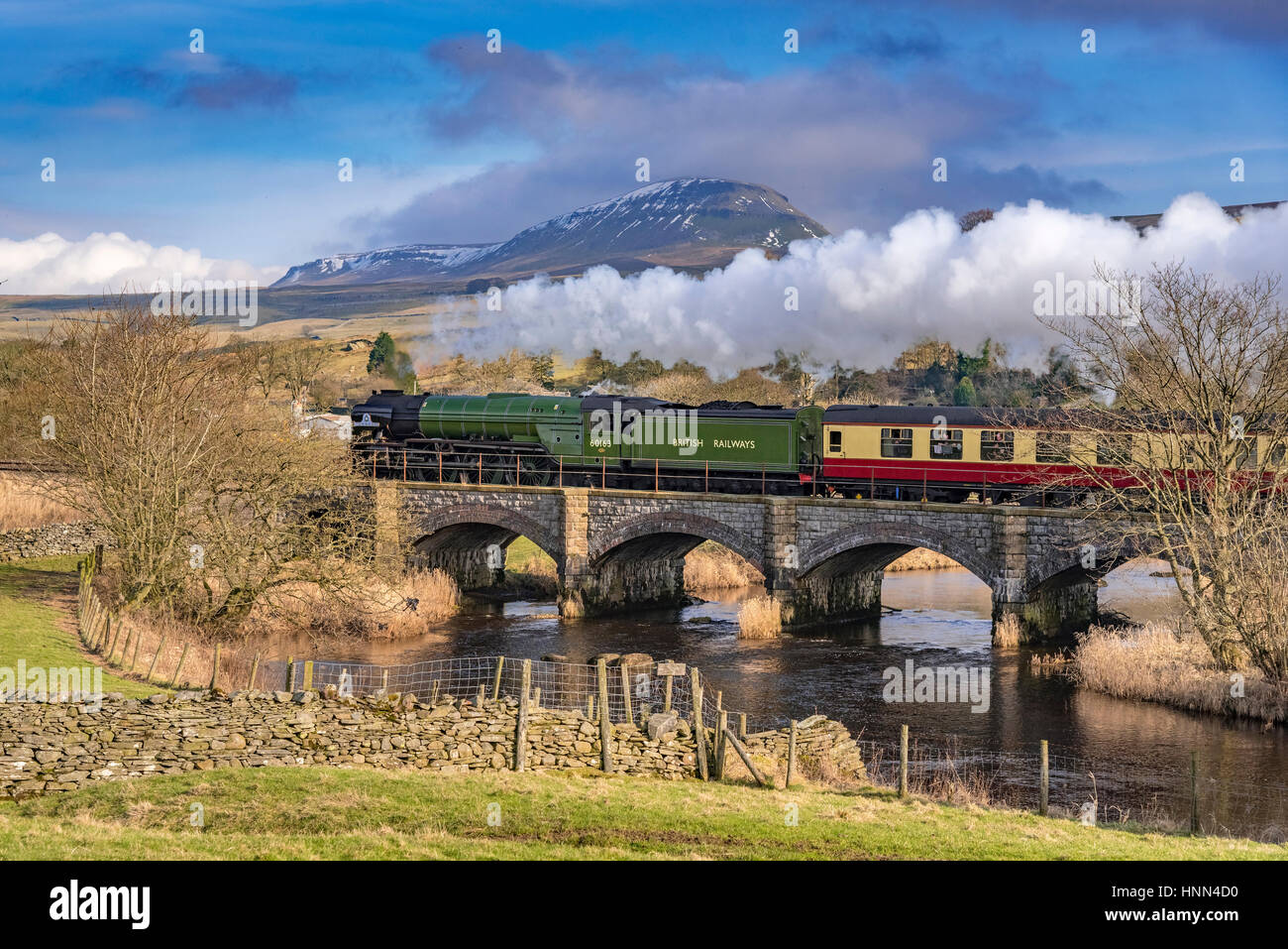 Helwith Bridge. North Yorkshire. North West England. Wednesday 15th February 2017. The Peppercorn steam engine Tornado on the secnond day of hauling scheduled trains between Skipton and Appleby on the Settle to Carlisle railway. The services are the first schedueld steam hauled services on British rail for 50 years. The train is pictured passing over Helwith Bridge with the towering Pen Y Ghent in the background. Credit: John Davidson/Alamy Live News. Stock Photo