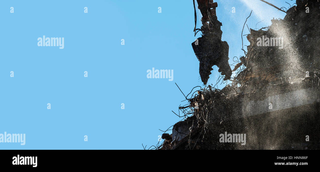 Jaws of High Reach Excavator Tearing Down Building Stock Photo
