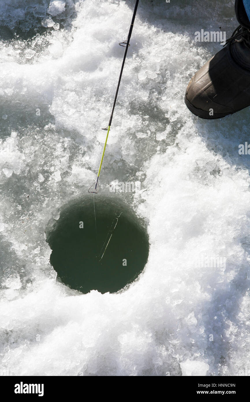 Reflection of pole and line in this ice fishing hole. Stock Photo