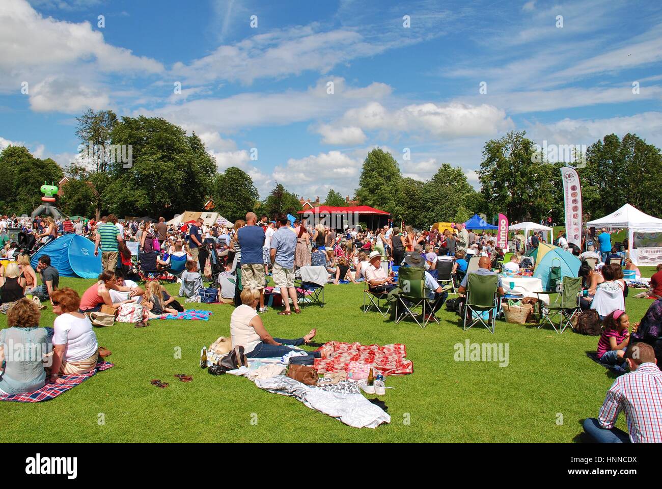 The audience sit on the grass at the annual Tentertainment music festival at Tenterden in Kent, England on June 30, 2012. Stock Photo