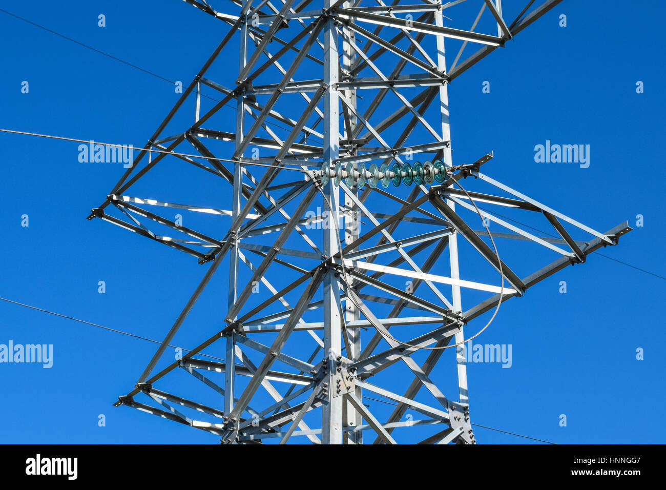 Supports high-voltage power lines against the blue sky Stock Photo - Alamy
