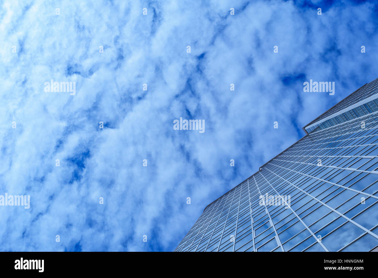 glass office building skyscraper on a background of clouds Stock Photo