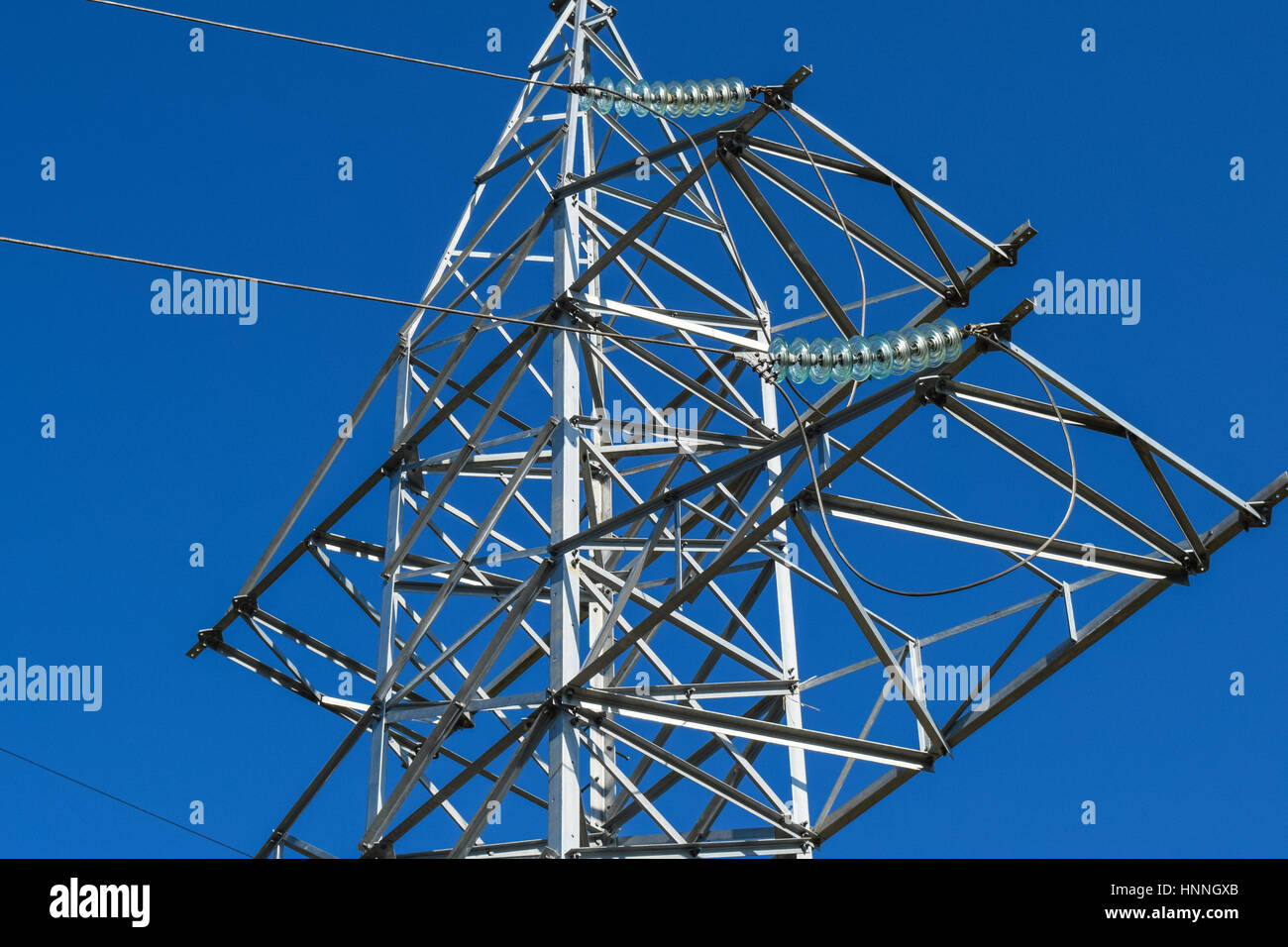 Supports high-voltage power lines against the blue sky Stock Photo - Alamy