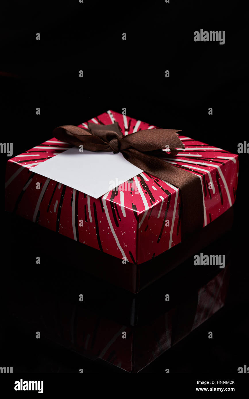 gift red colorful box with brown ribbon on black background isolated Stock Photo
