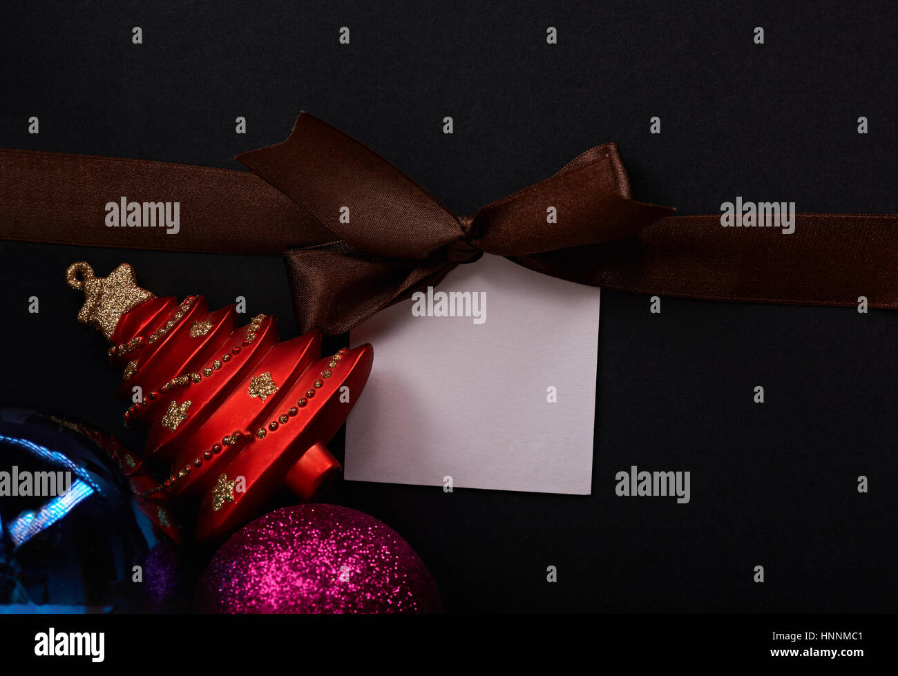 Dark christmas background with brown ribbon bow and christmas toys Stock Photo