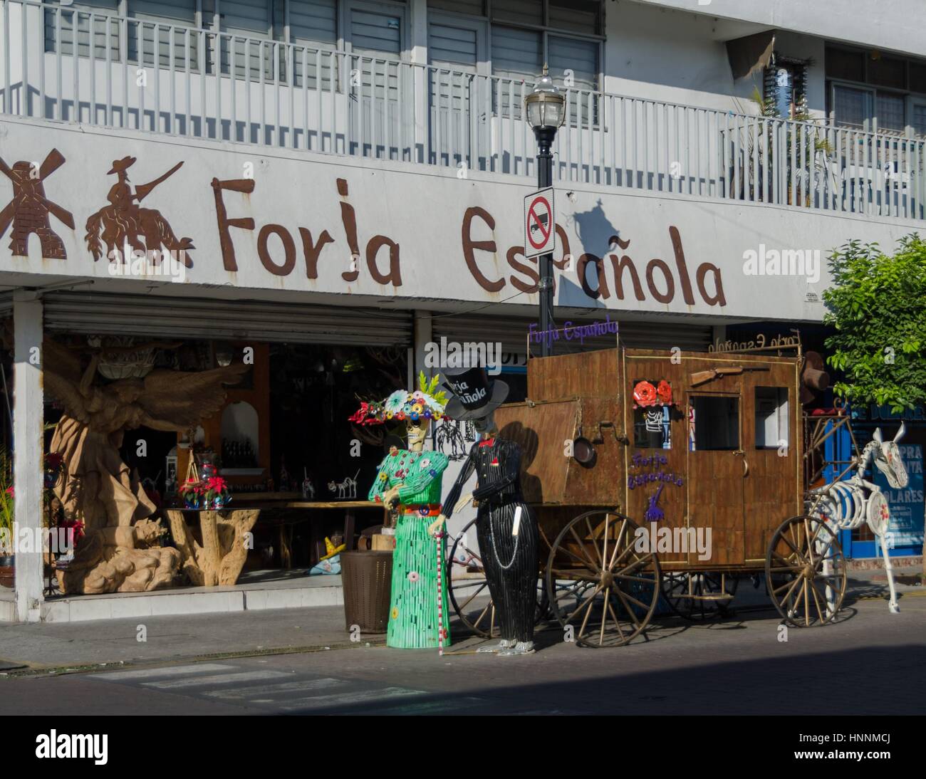 A store in Tlaquepaque, Guadalajara promotes it's wares with a display of a stage coach with Catrina and partner. Stock Photo