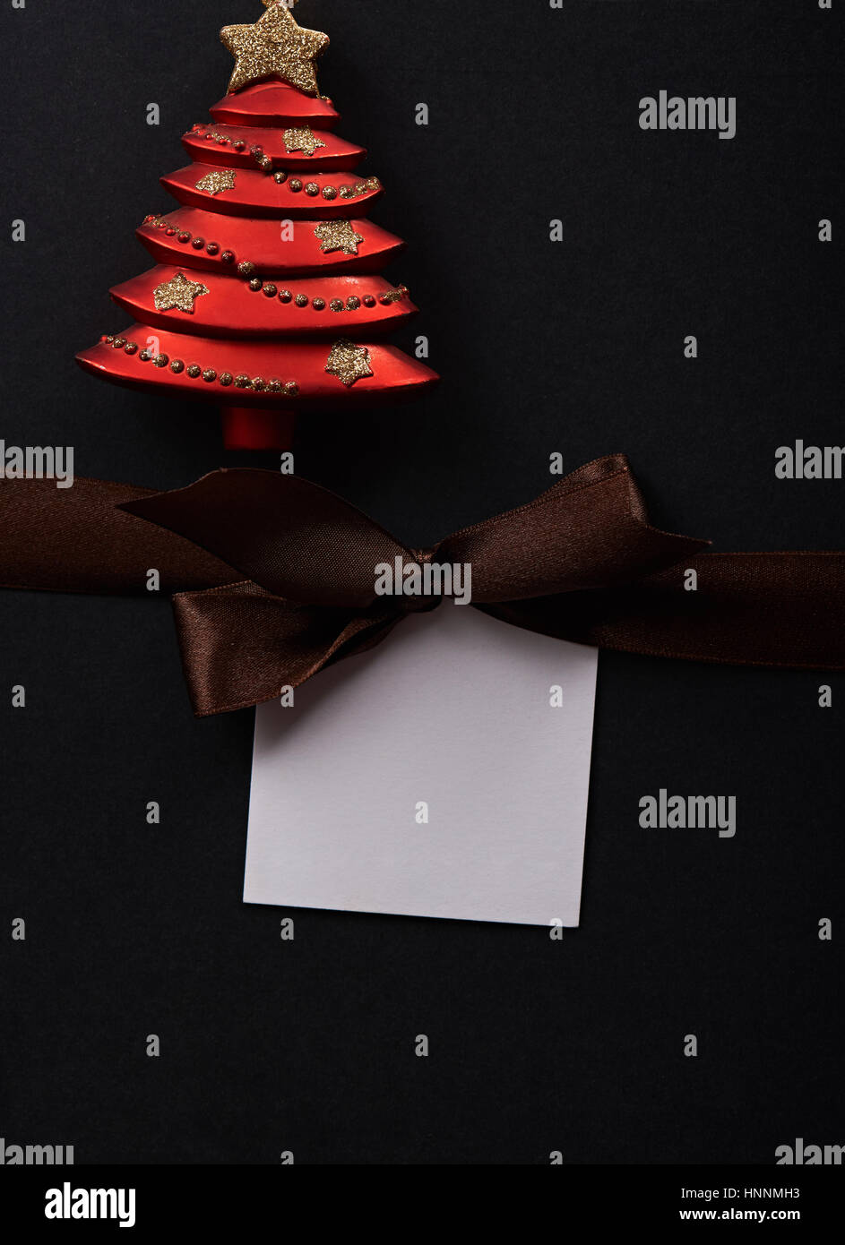 Gift paper tag with brown bow and christmas toy decoration. Red christmas toy Stock Photo