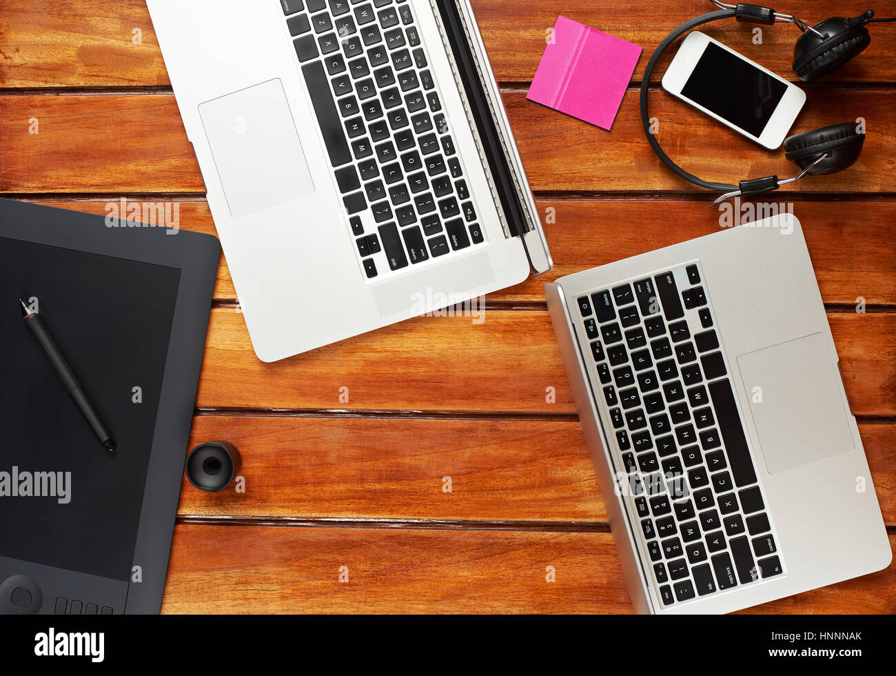 Designer wooden desk with laptops and graphic designer tablet view