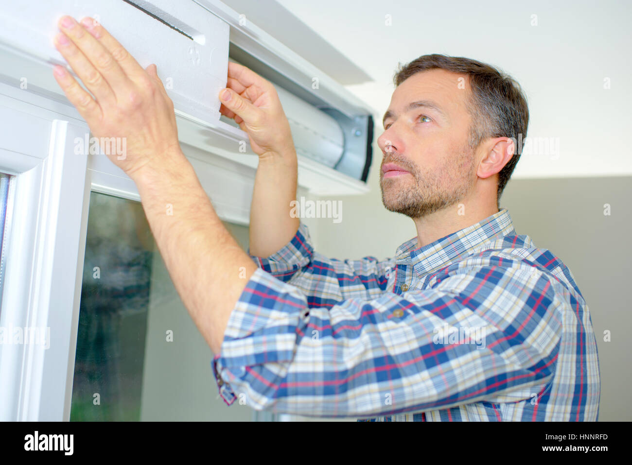 Handyman installing a window shutter Stock Photo Alamy