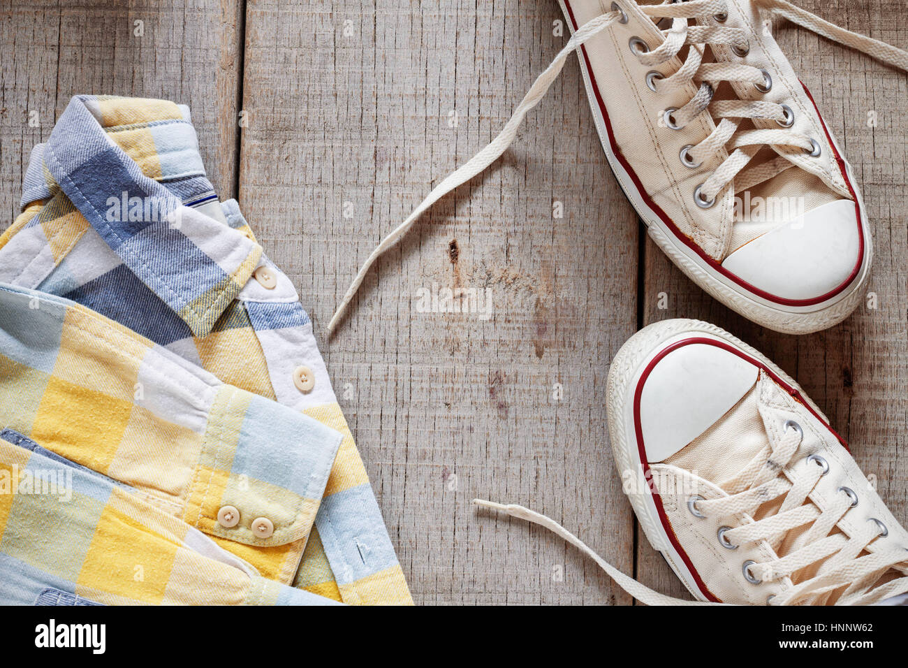 Shirt and sneakers on the old wooden floor Stock Photo - Alamy
