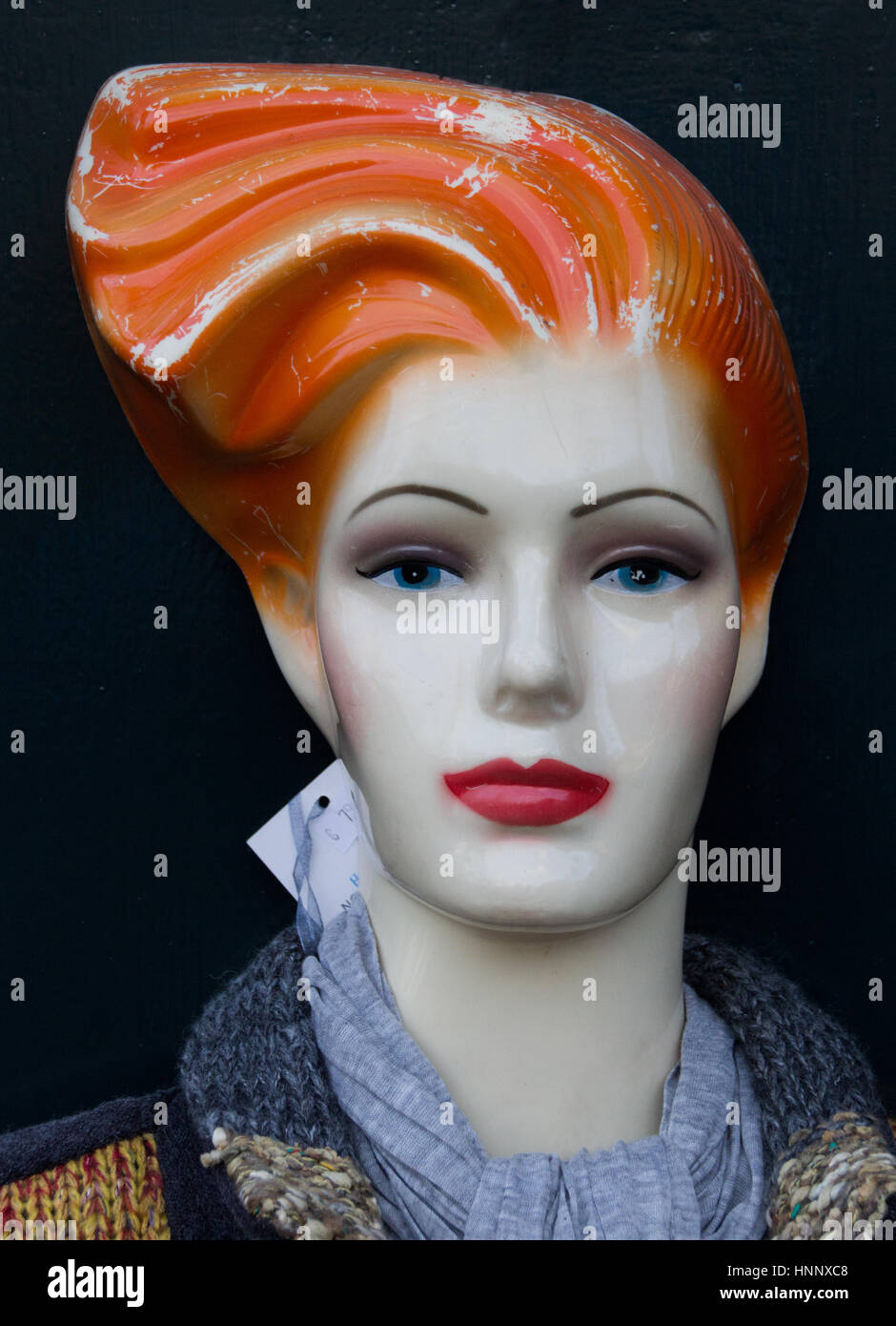 Worn mannequin with red lips and orange hair Stock Photo