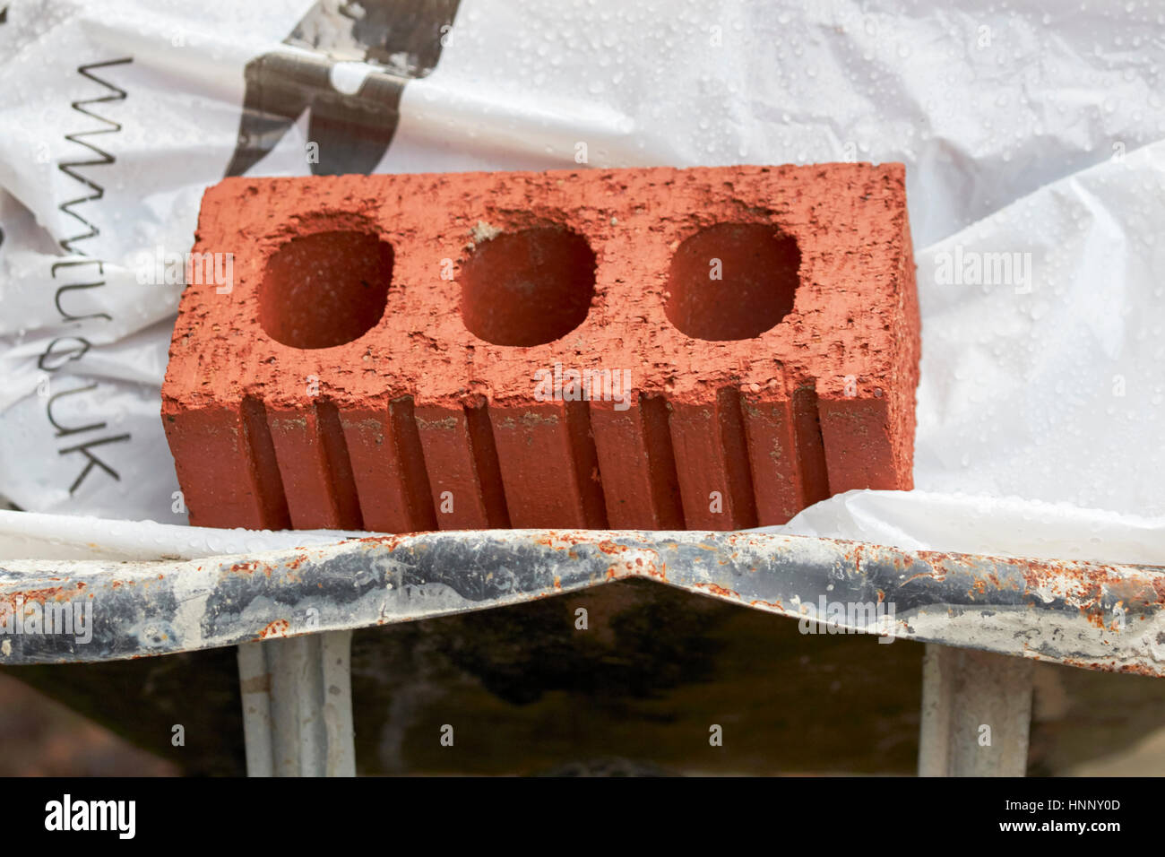 red rustic brick in an old wheelbarrow Stock Photo