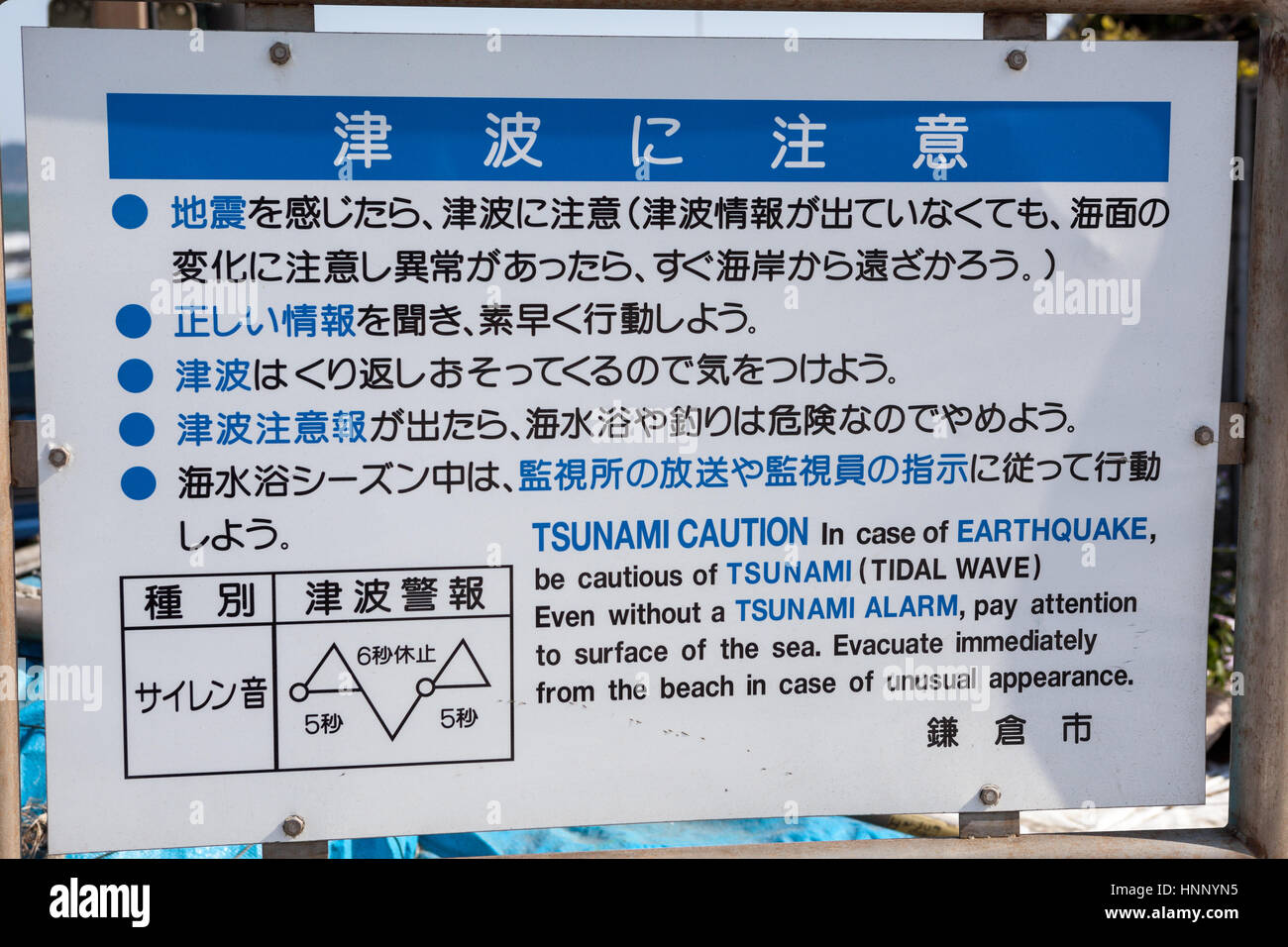 KAMAKURA, JAPAN - CIRCA APR, 2013: Tsunami caution plate is on the ocean shore of Nagai beach. Instruction for evacuation in case of earthquake or unu Stock Photo