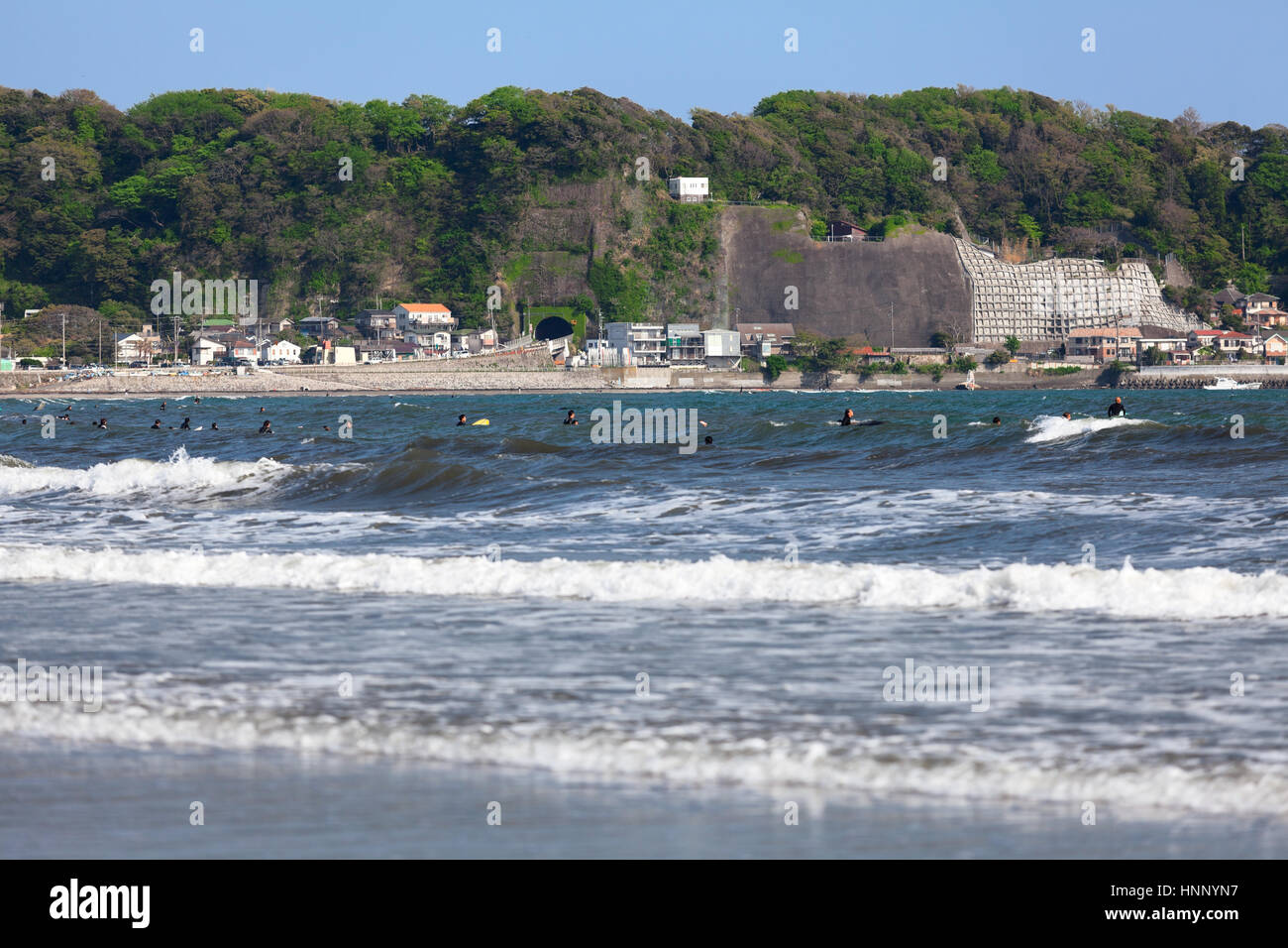 Many surfers catch the wave on low tide shore in Yuigahama beach. The Sagami Bay is famous for wind surfing. Low season time. Kamakura, Japan Stock Photo
