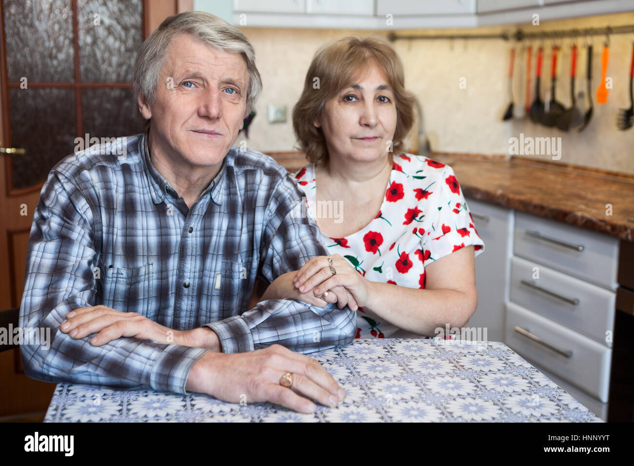 Caucasian elderly couple sitting at the kitchen dinner table and ...