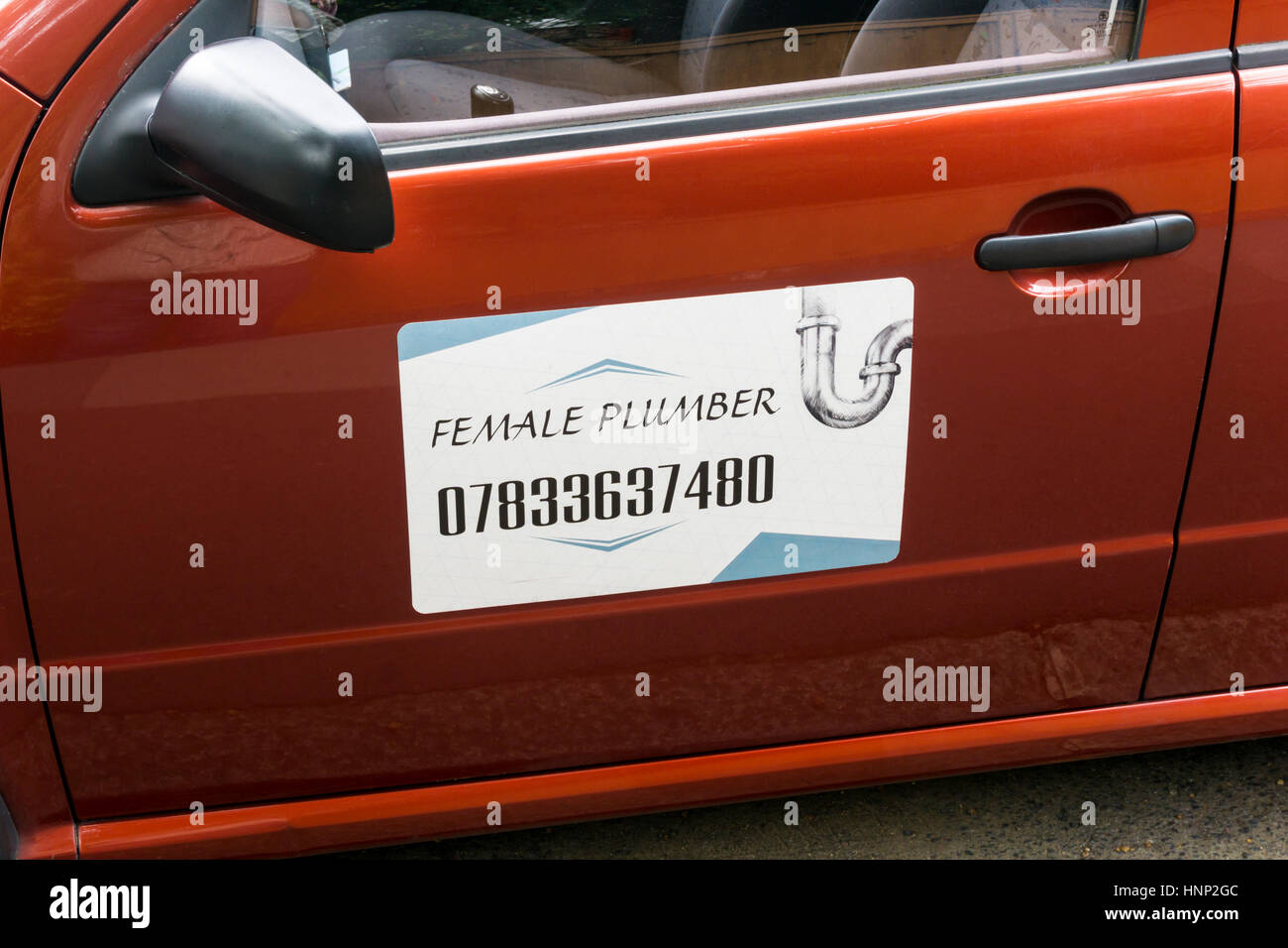 Sign on the side of a car advertising a female plumber. Stock Photo