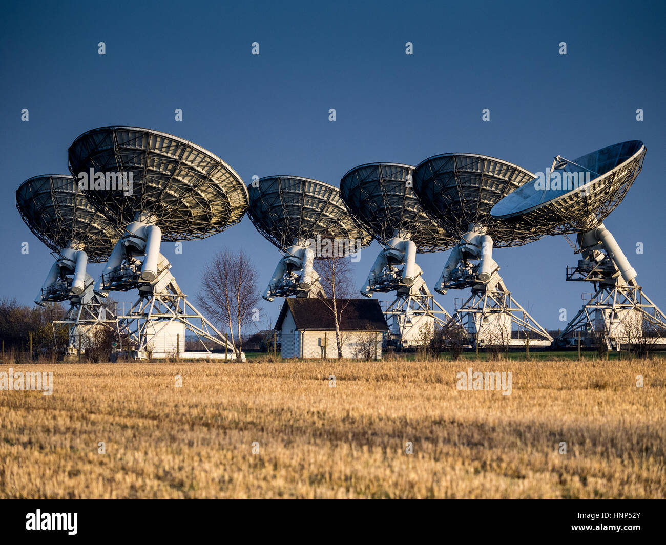 Several radio telescopes, part of the Mullard Radio Astronomy Observatory Arcminute Microkelvin Imager Large Array nr Cambridge. Stock Photo