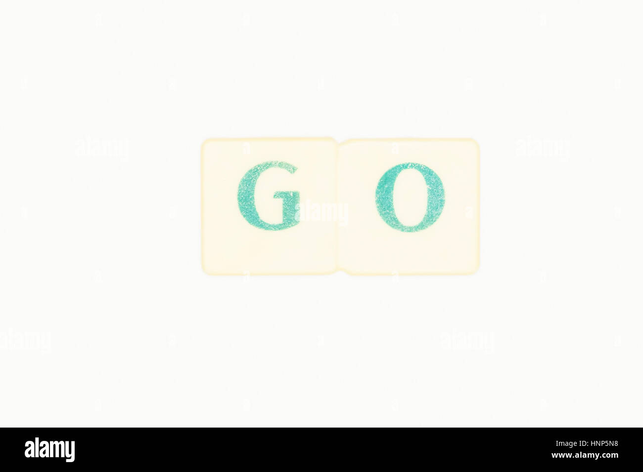 Photo Of Two Green Letters Forming The Word Go An Irregular Verb In The English Language, Word Written On A White Background Stock Photo