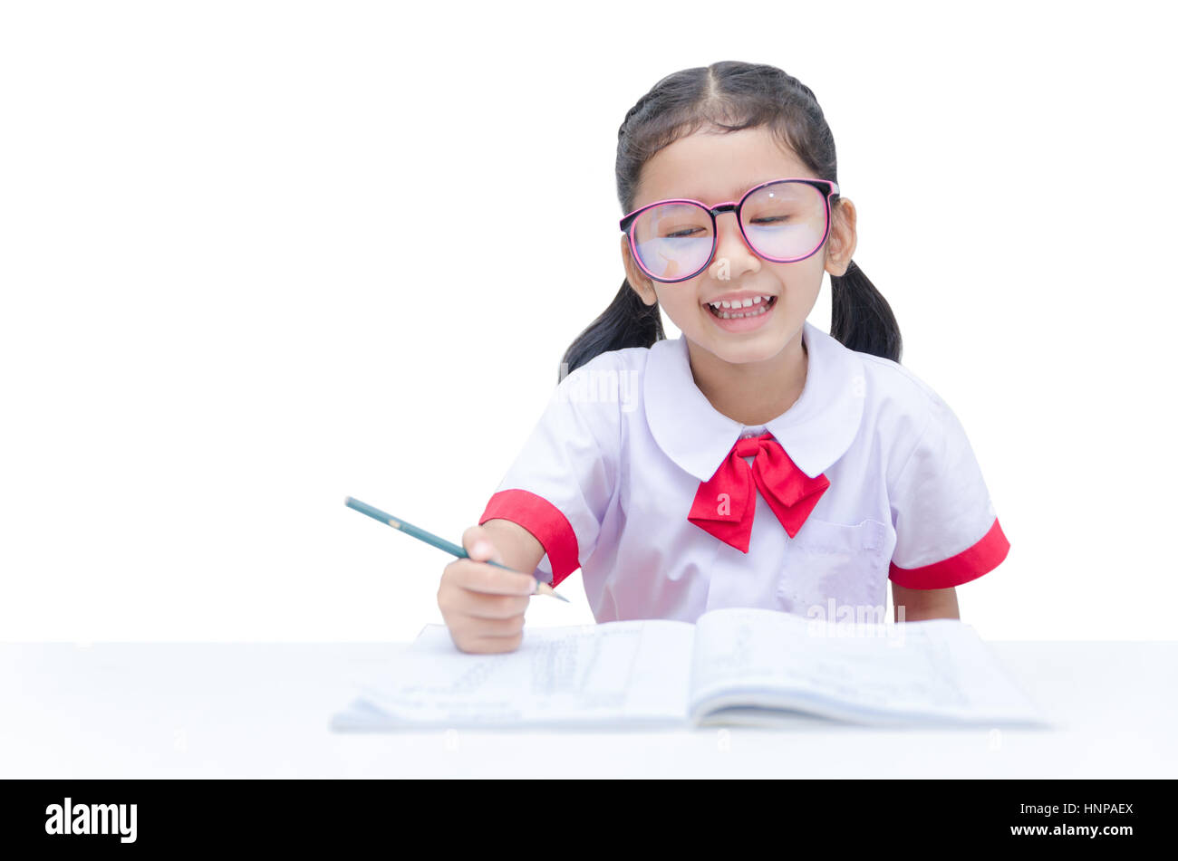 Asian little girl doing homework with smile isolated on white background with clipping path Stock Photo