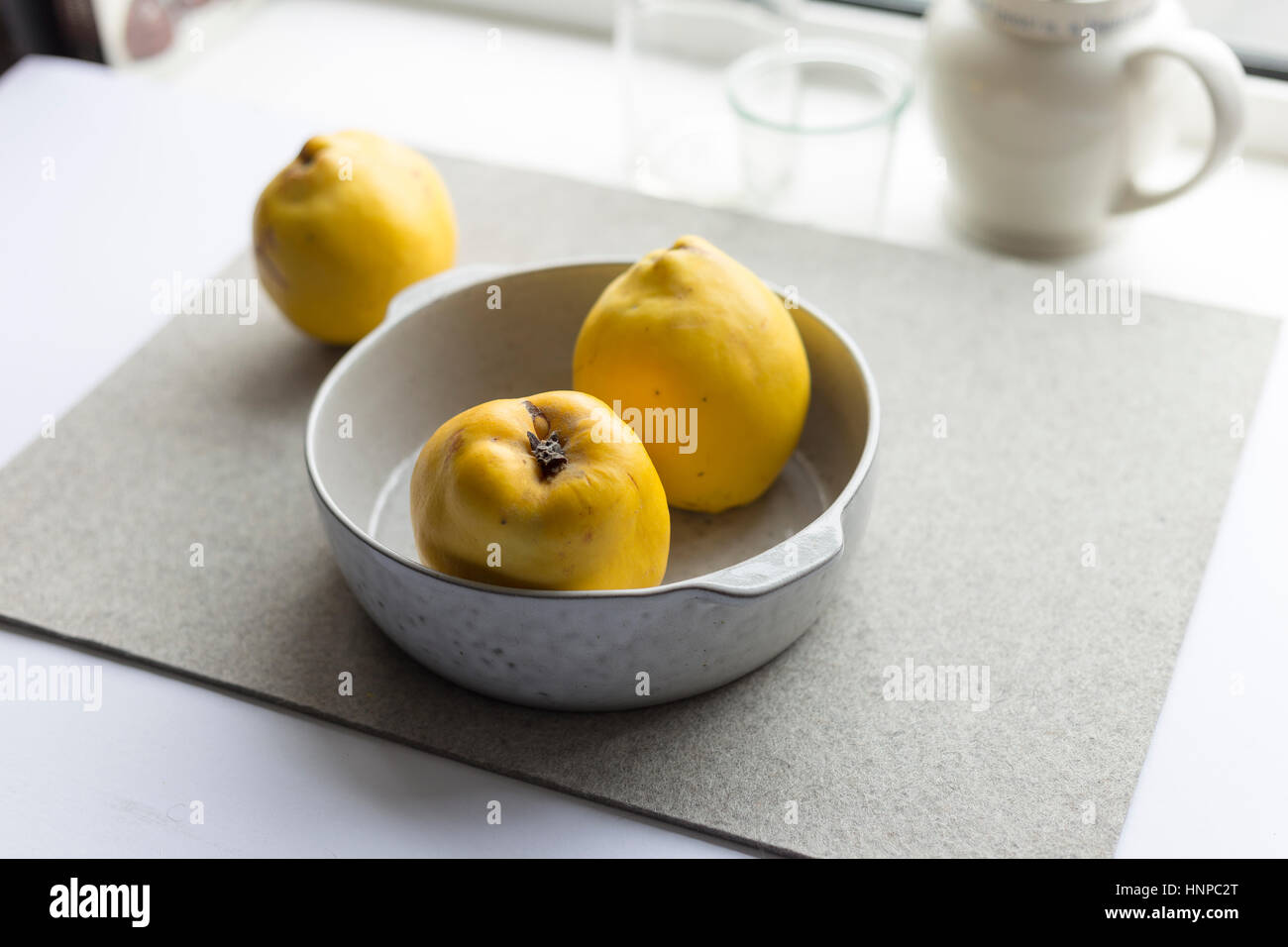 Bowl of quinces on table Stock Photo