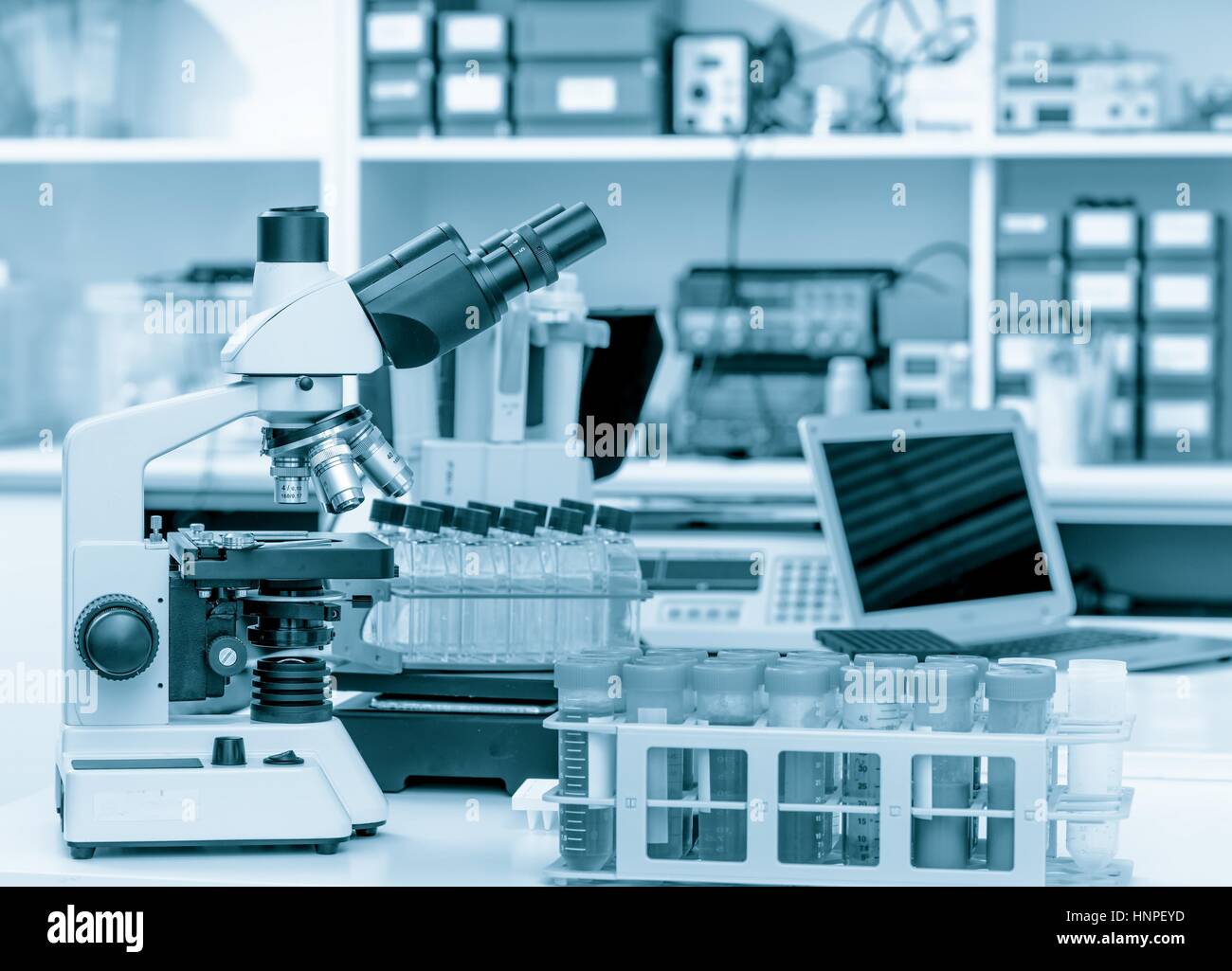 Science laboratory with a microscope, biological material samples and a computer on a desk. Selective focus with bokeh. Rack with samples and chemical Stock Photo