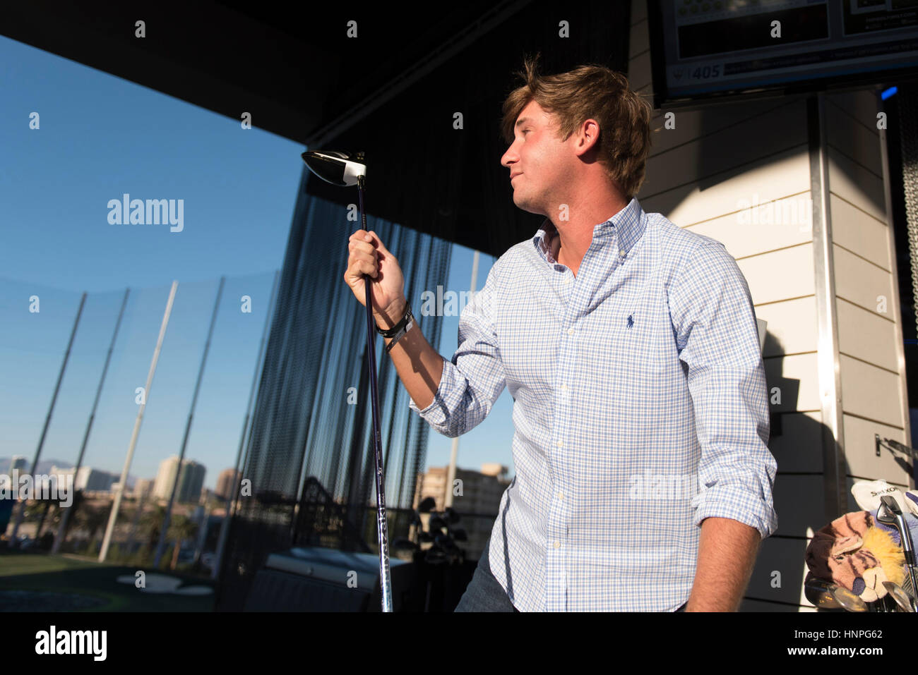 Smylie Kaufman changes clubs inbetween hitting golf balls at Topgolf's