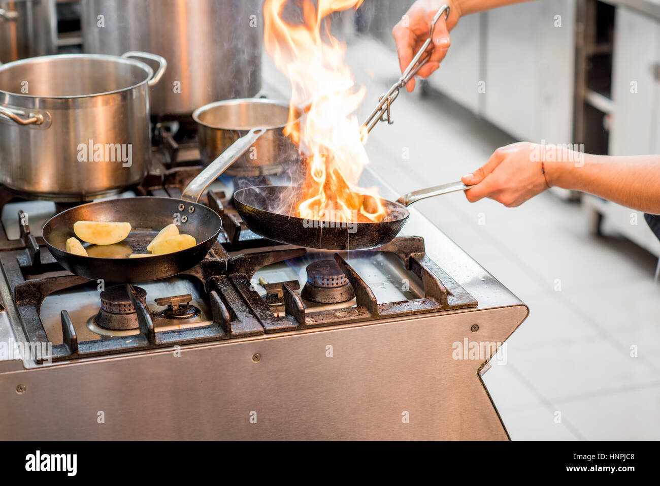 Chef Frying Meat Steak On The Gas Stove With Fire At The Kitchen