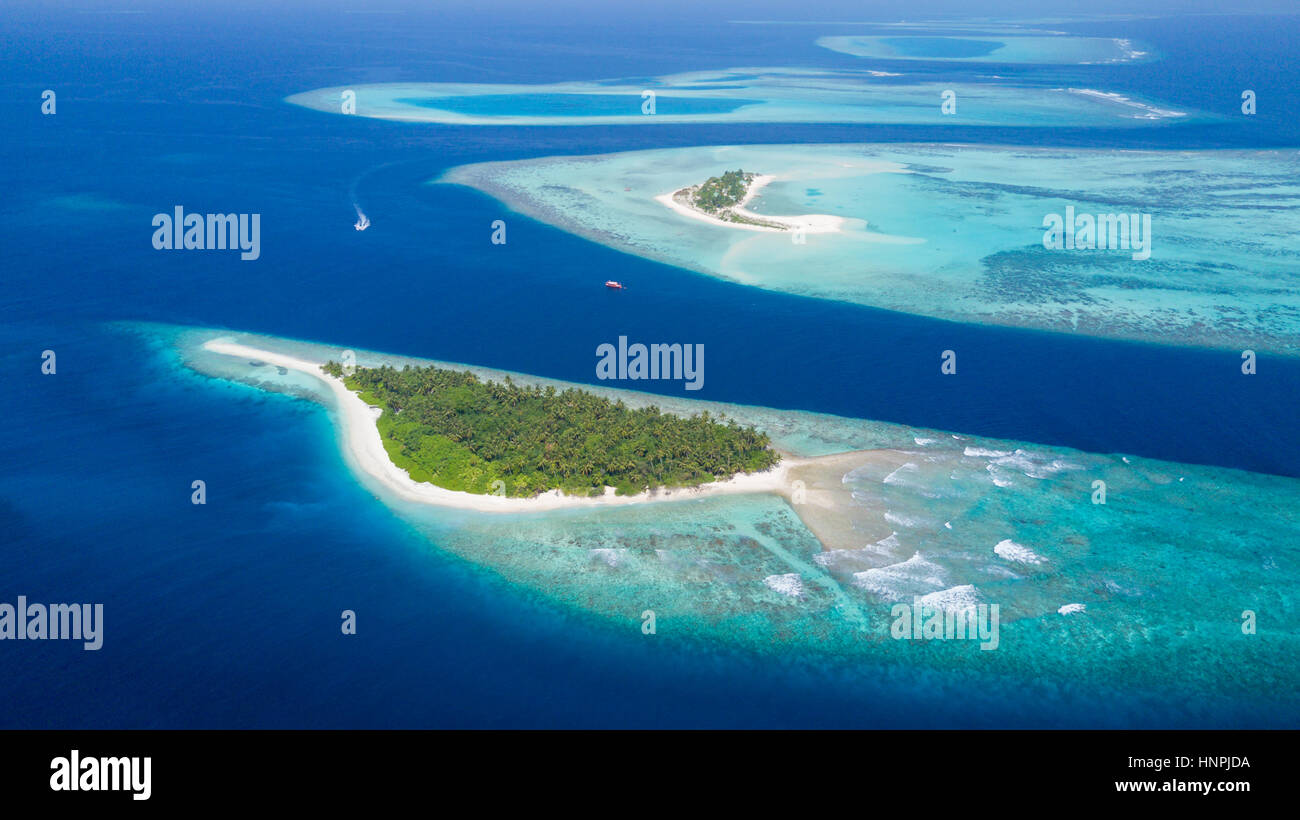 Small tropical island in Maldives atoll from aerial view Stock Photo