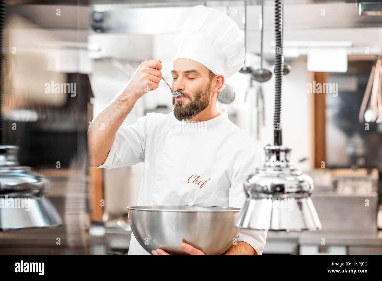 Chef cook tasting food with wooden spoon at the restaurant kitchen Stock  Photo - Alamy