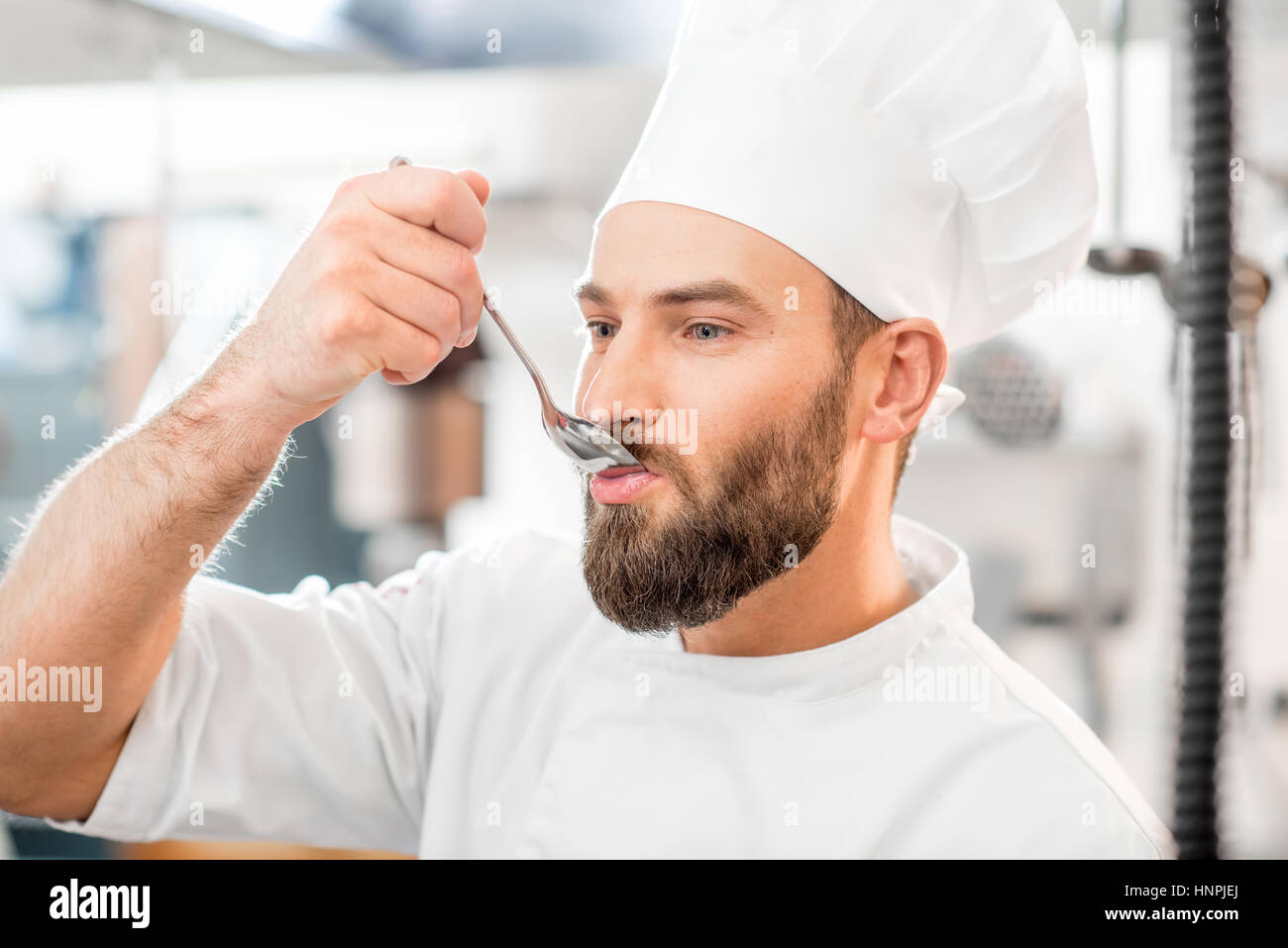 Premium Photo  Chef cook tasting food with wooden spoon at the restaurant  kitchen