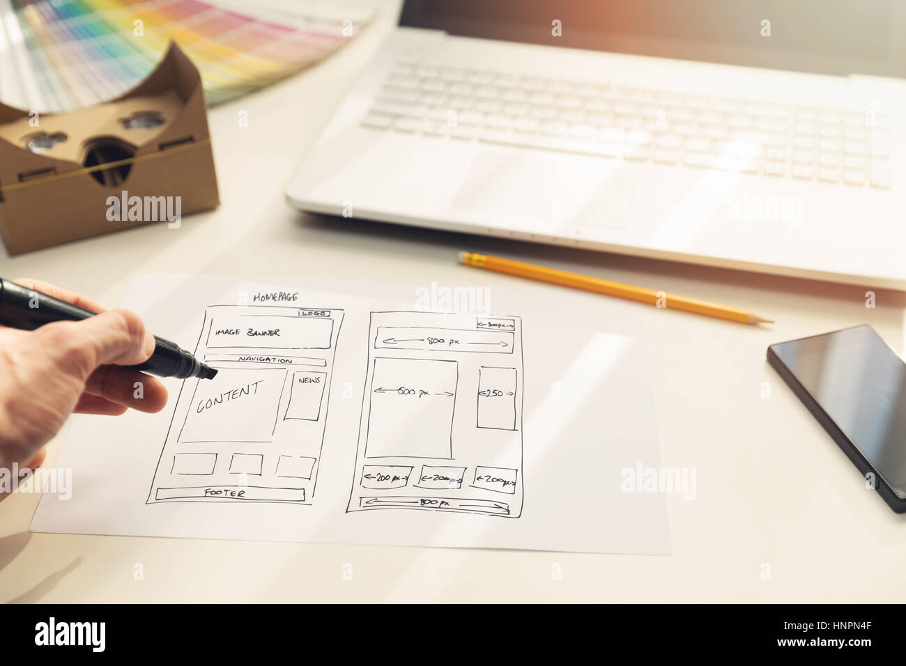 designer drawing website development wireframe on paper in office Stock Photo