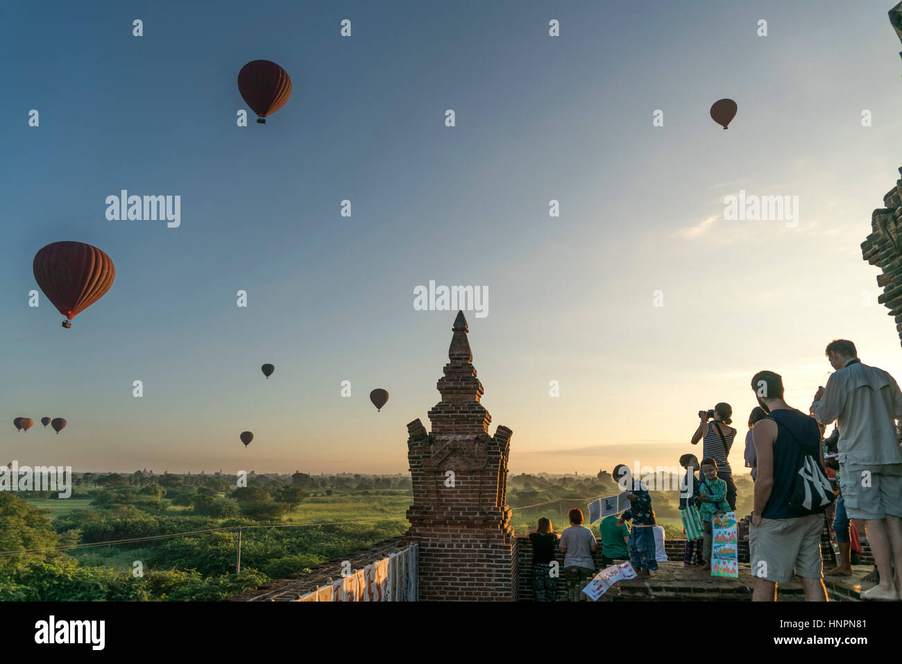 Touristen beobachten die Heißluftballons in der Ebene von Bagan, Myanmar, Asien  |  tourists watching the ballons flying over Bagan Plains temples and Stock Photo