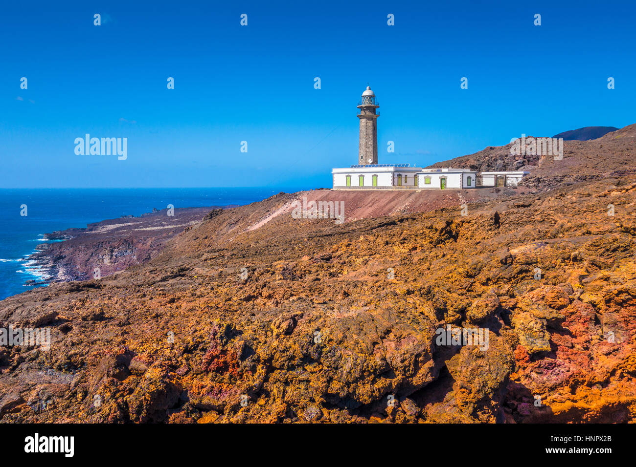 Beautiful view of famous El Faro de Punta Orchilla lighthouse with red volcanic scenery and wide open sea on a sunny day, El Hierro, Canary Islands Stock Photo