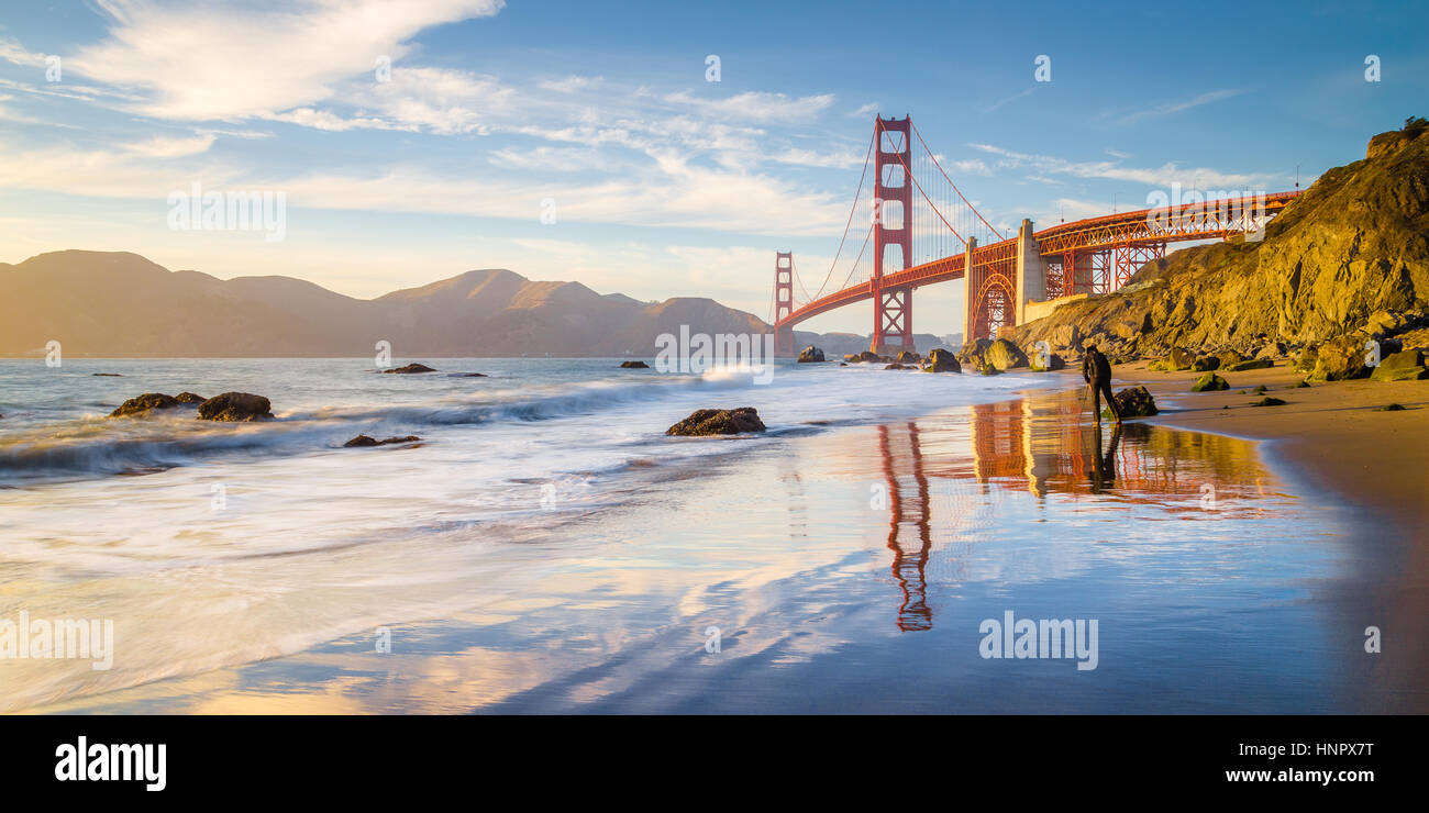 Classic panoramic view of famous Golden Gate Bridge seen from scenic Baker Beach in beautiful golden evening light at sunset, San Francisco, California Stock Photo