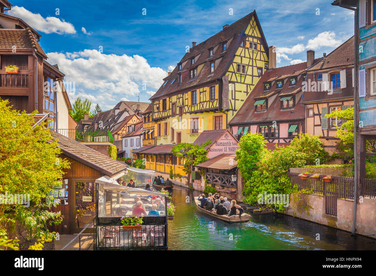 Beautiful view of the historic town of Colmar, also known as Little Venice, with tourists taking a boat ride on river Lauch, Alsace region, France Stock Photo