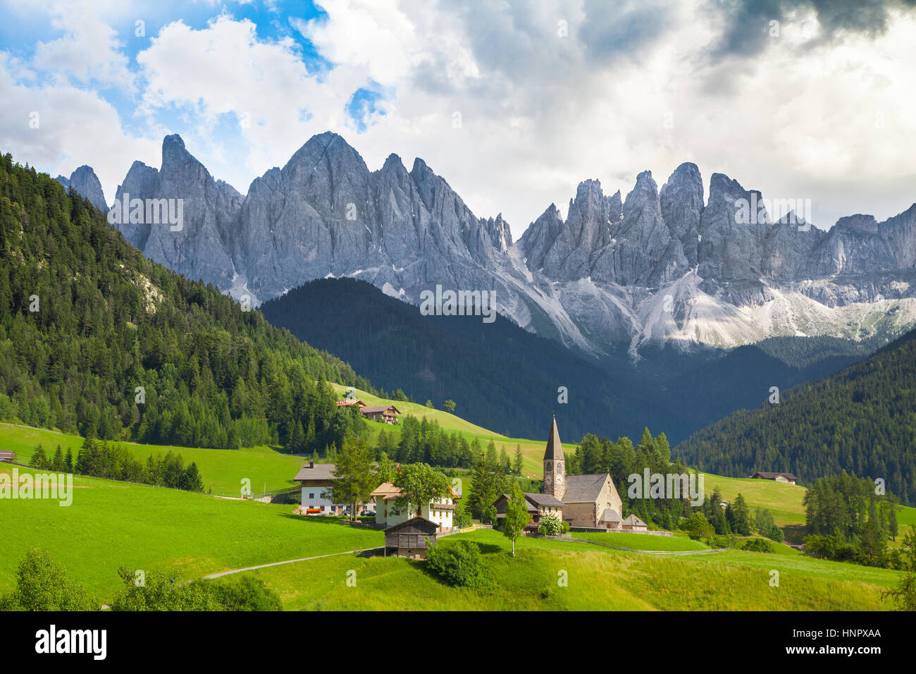 Beautiful view of idyllic mountain scenery in the Dolomites with famous Santa Maddelana mountain village on a sunny day in summer, Val di Funes, Italy Stock Photo