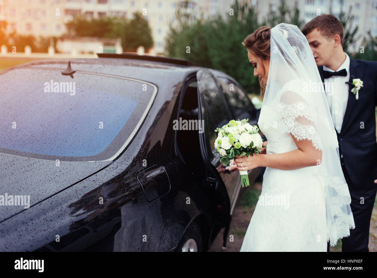 Happy bride and groom near car Stock Photo - Alamy