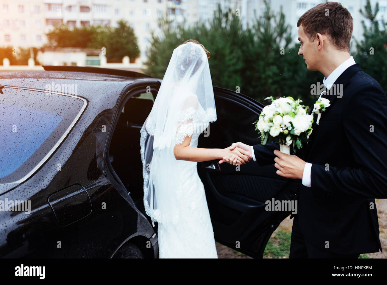 Happy bride and groom near car Stock Photo - Alamy