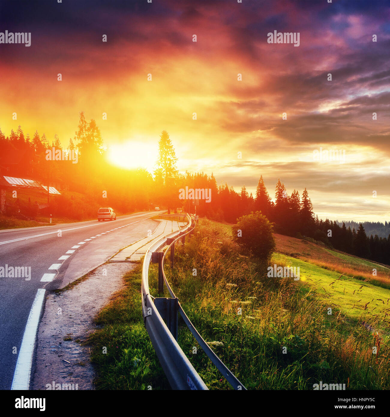 Fantastic sunset that leads into the mountains. Asphalt road wit Stock ...