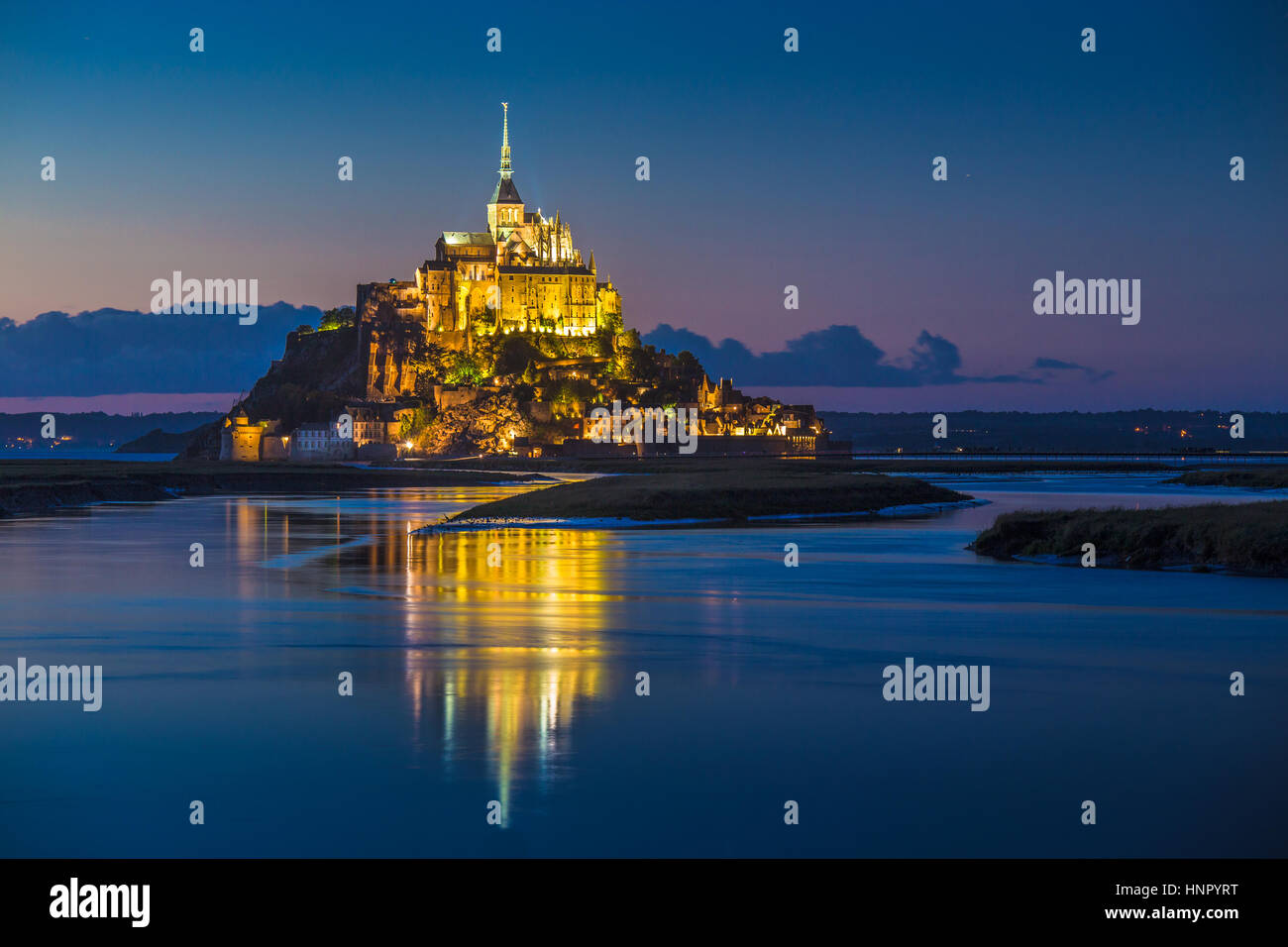 Classic view of famous Le Mont Saint-Michel tidal island in beautiful twilight during blue hour at dusk, Normandy, northern France Stock Photo