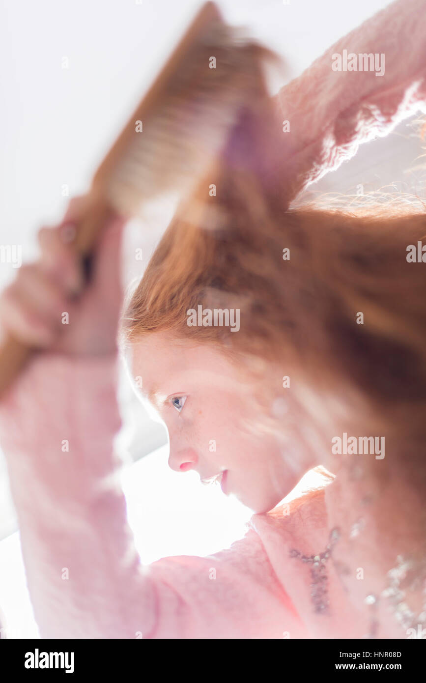 A little girl brushing her red hair Stock Photo Alamy