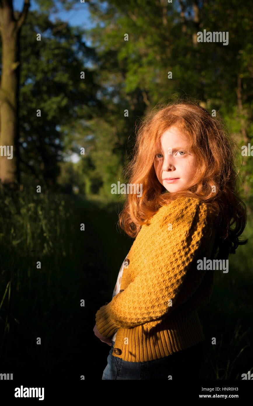 Portrait of an 8 year old girl with ginger hair outdoors Stock Photo