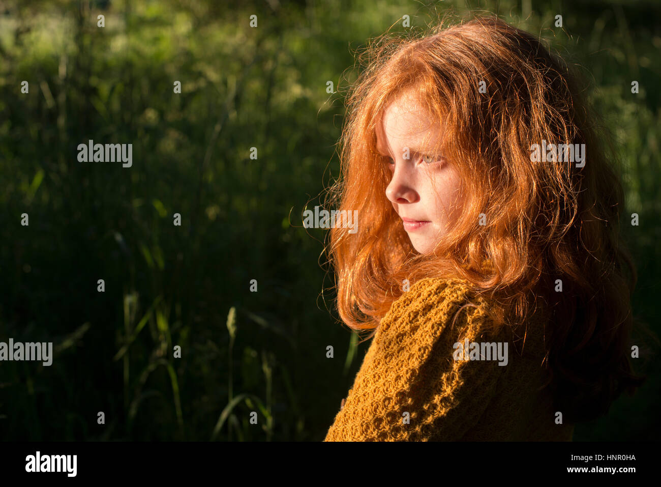 Portrait of an 8 year old girl with ginger hair outdoors Stock Photo