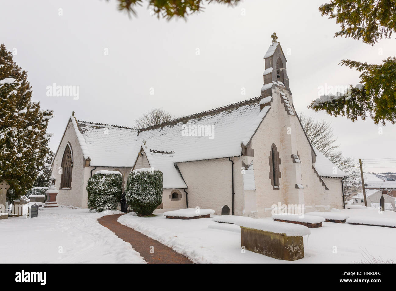Saint Digains church Llangernyw in deep snow with the Llangernyw Yew on the left Stock Photo