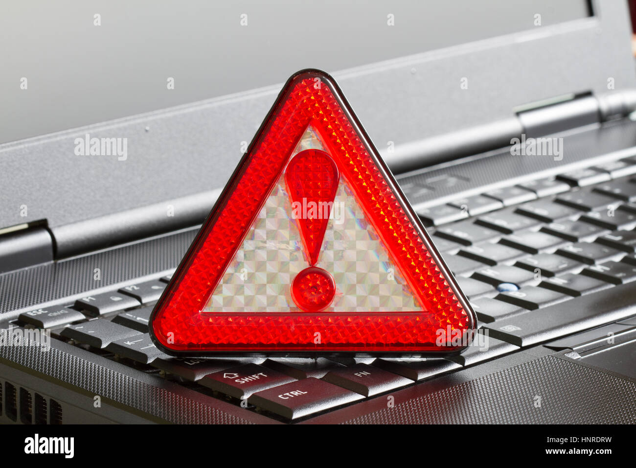 Caution sign on black laptop computer virus detected alert hacking piracy concept Stock Photo