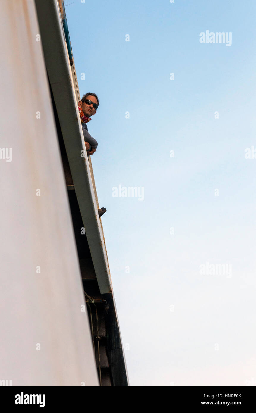 Passenger looking out from the deck of the ferry at the shores of Koh Chang in Thailand. Stock Photo