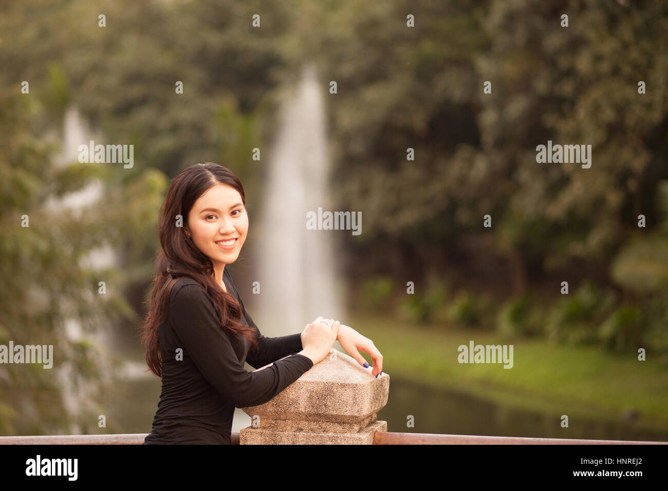 Pretty Thai girl Smiling at the park Stock Photo