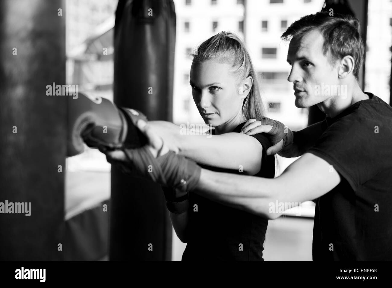Black-white photo of girl workout with coach in gym Stock Photo
