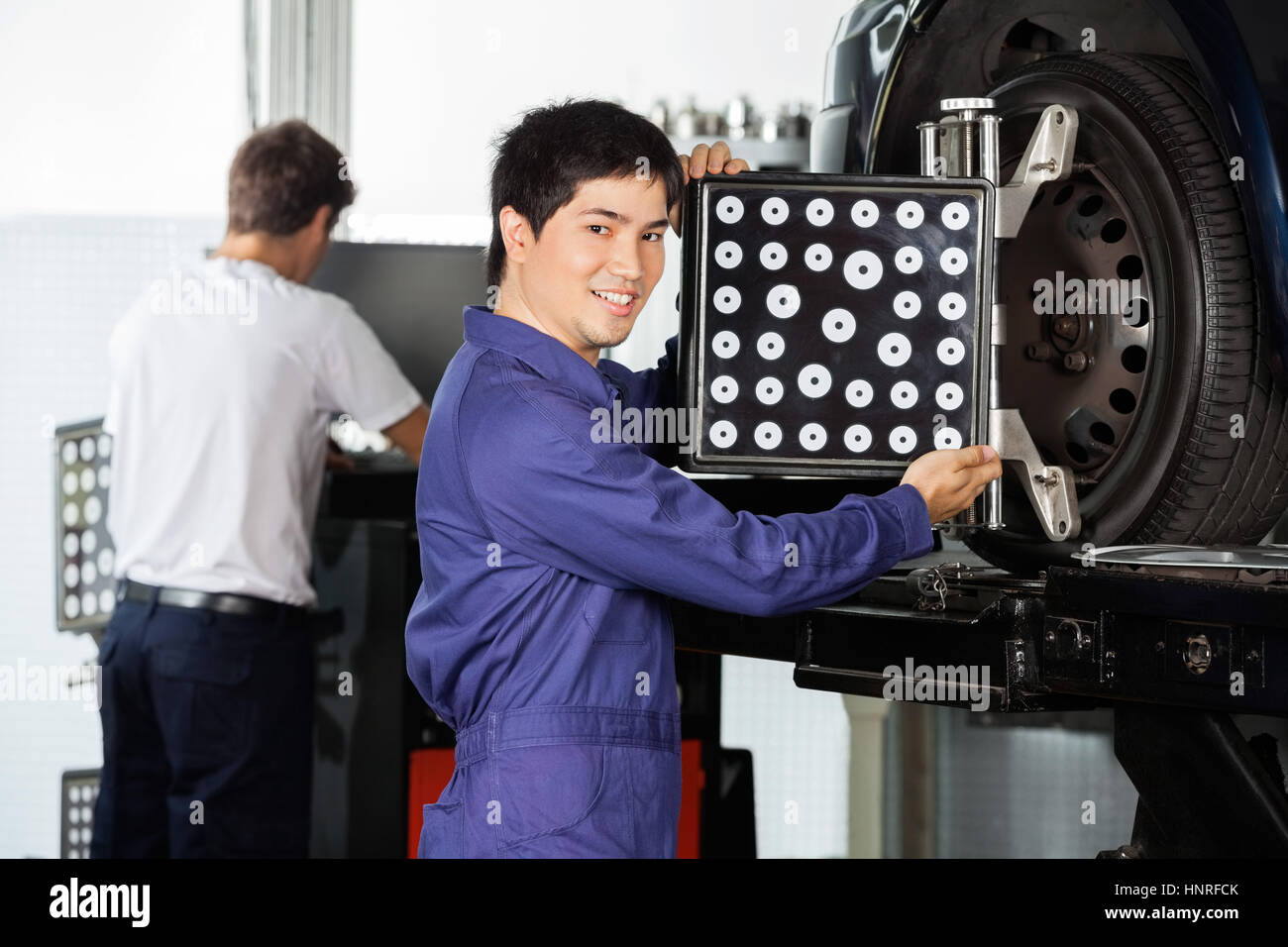 Confident Mechanic Adjusting Wheel Aligner On Car Tire Stock Photo - Alamy