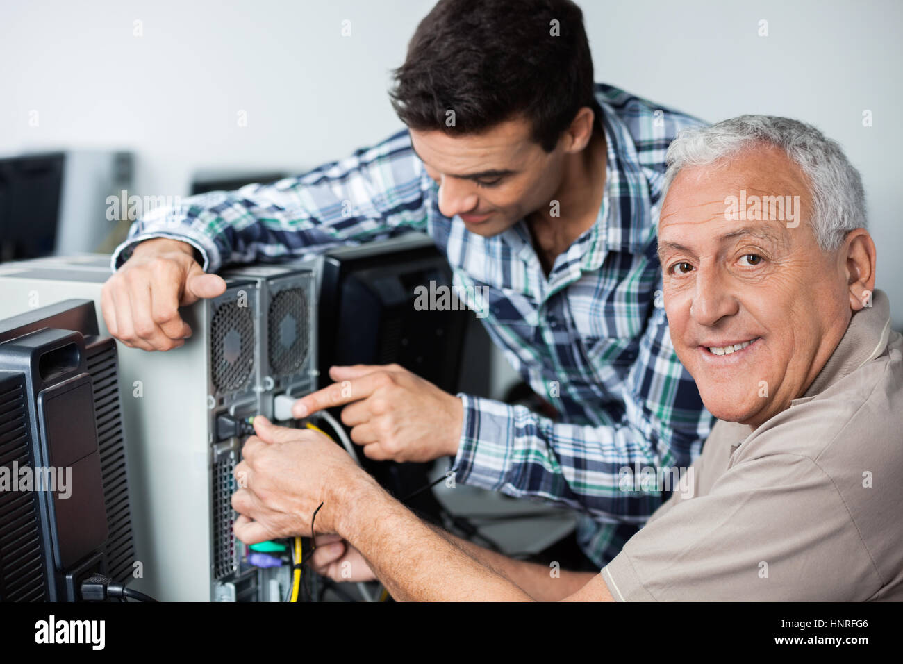 Man Installing Computer Happy Senior Man With Teacher Installing Computer In Classroom Stock ...